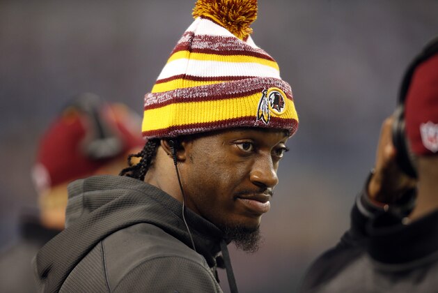 Washington Redskins quarterback Robert Griffin III (10) talks with a teammate on the sideline during an NFL football game against the Dallas Cowboys, Monday, Oct. 27, 2014, in Arlington, Texas. (AP Photo/Tim Sharp)