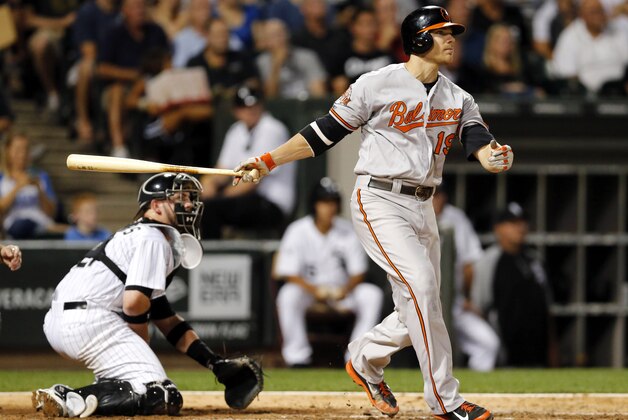 Baltimore Orioles' Chris Davis watches his two-run double off Chicago White Sox starting pitcher Jose Quintana, scoring Delmon Young and J.J. Hardy, during the sixth inning of a baseball game Tuesday, Aug. 19, 2014, in Chicago. Also watching the play is catcher Tyler Flowers. (AP Photo/Charles Rex Arbogast)