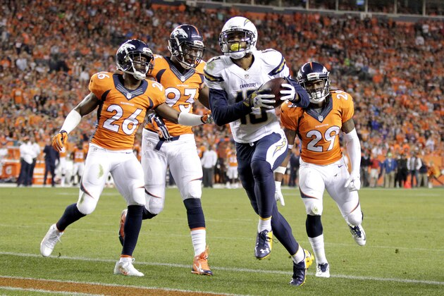 San Diego Chargers wide receiver Keenan Allen (13) scores a touchdown as Denver Broncos free safety Rahim Moore (26), Quanterus Smith (93) and Bradley Roby (29) defend during the first half of an NFL football game, Thursday, Oct. 23, 2014, in Denver. (AP Photo/Joe Mahoney)