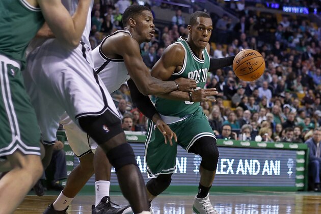 Boston Celtics guard Rajon Rondo dribbles against Brooklyn Nets guard Joe Johnson, left, in the first quarter of an NBA basketball game in Boston, Wednesday, Oct. 29, 2014. (AP Photo/Elise Amendola)
