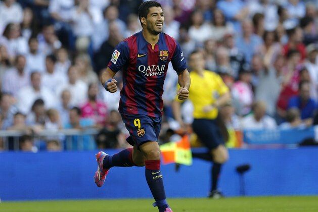Barcelona's Luis Suarez, celebrates after Barcelona's Neymar scored during a Spanish La Liga soccer match between Real Madrid and Barcelona at the Santiago Bernabeu stadium in Madrid, Spain, Saturday Oct. 25, 2014. (AP Photo/Paul White)