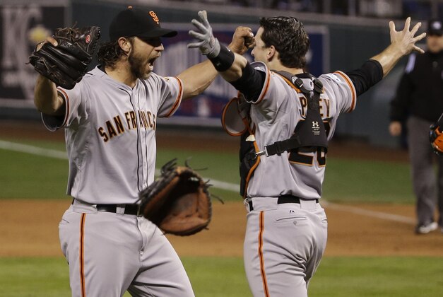 San Francisco Giants pitcher Madison Bumgarner, left, and Buster Posey celebrate after winning 3-2 to win the series over Kansas City Royals after Game 7 of baseball's World Series Wednesday, Oct. 29, 2014, in Kansas City, Mo. (AP Photo/Matt Slocum)