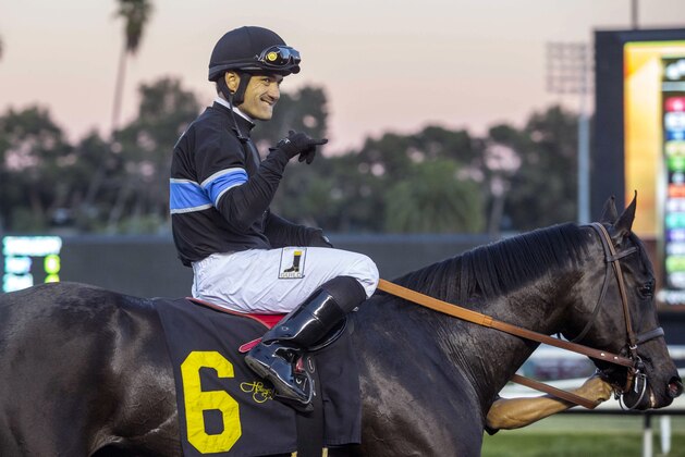 Jockey Corey Nakatani celebrates with Shared Belief after winning the CashCall Futurity horse race at Betfair Hollywood Park in Inglewood, Calif., on Saturday, Dec. 14, 2013. (AP Photo/Ringo H.W. Chiu)