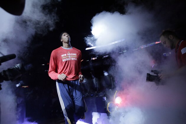 New Orleans Pelicans forward Anthony Davis (23) runs onto the court during player introductions before an NBA basketball game against the Orlando Magic in New Orleans, Tuesday, Oct. 28, 2014. (AP Photo/Gerald Herbert)