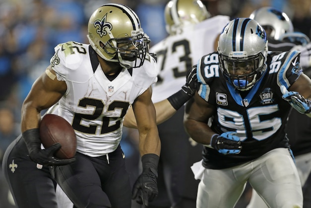 New Orleans Saints' Mark Ingram (22) runs as Carolina Panthers' Charles Johnson (95) closes in during the first half of an NFL football game in Charlotte, N.C., Thursday, Oct. 30, 2014. (AP Photo/Bob Leverone)