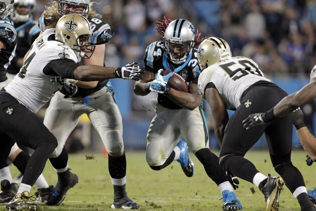 Carolina Panthers' DeAngelo Williams (34) tries to run between New Orleans Saints' Curtis Lofton (50) and Cameron Jordan (94) in the second half of an NFL football game in Charlotte, N.C., Thursday, Oct. 30, 2014. (AP Photo/Bob Leverone)