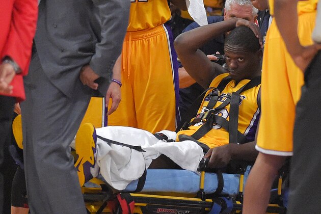 Los Angeles Lakers forward Julius Randle, right, sits on on a stretcher after Randle injured himself on a play during the second half of an NBA basketball game, Tuesday, Oct. 28, 2014, in Los Angeles. (AP Photo/Mark J. Terrill)