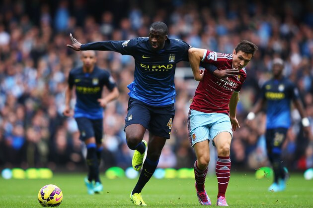 LONDON, ENGLAND - OCTOBER 25:  Yaya Toure of Manchester City is tackled by Stewart Downing of West Ham United during the Barclays Premier League match between West Ham United and Manchester City at Boleyn Ground on October 25, 2014 in London, England.  (Photo by Ian Walton/Getty Images)