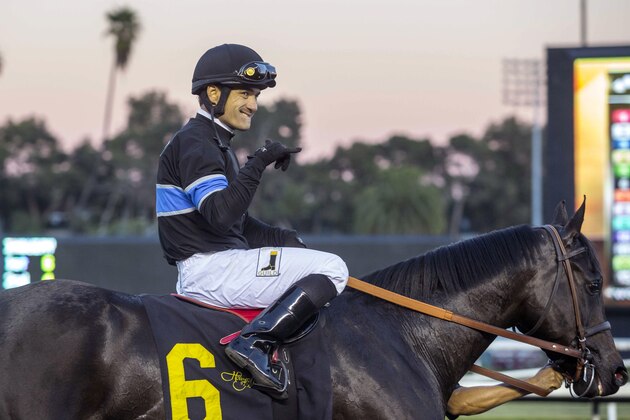 Jockey Corey Nakatani celebrates with Shared Belief after winning the CashCall Futurity horse race at Betfair Hollywood Park in Inglewood, Calif., on Saturday, Dec. 14, 2013. (AP Photo/Ringo H.W. Chiu)