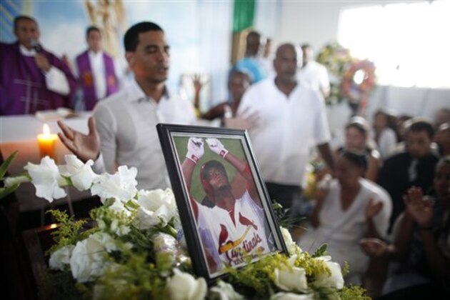 A photo St. Louis Cardinals outfielder, Oscar Taveras stands on top of the coffin containing his body during his funeral in Sosua, Dominican Republic, Tuesday, Oct. 28, 2014. Taveras died Sunday in a car accident in his native Dominican Republic. He was 22. (AP Photo/Ricardo Arduengo)