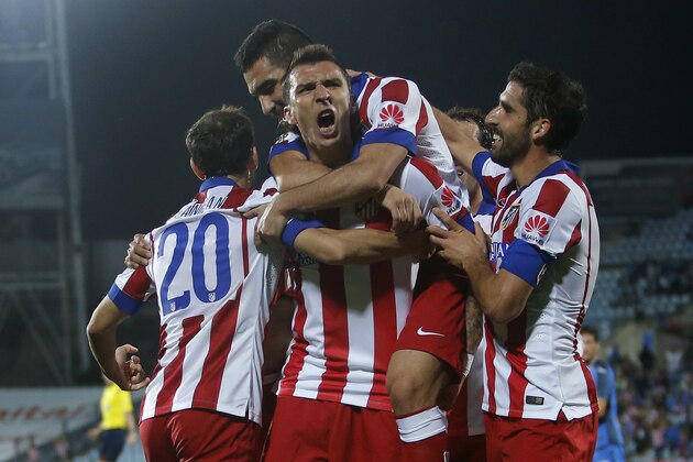 Atletico's Mario Mandzukic, centre, celebrates his goal with team mates during a Spanish La Liga soccer match between Atletico de Madrid and Getafe at the Coliseum Alfonso Perez stadium in Madrid, Spain, Sunday, Oct. 26, 2014. (AP Photo/Andres Kudacki)