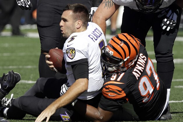 Baltimore Ravens quarterback Joe Flacco, left, is wrapped up by Cincinnati Bengals defensive tackle Geno Atkins after losing his helmet during the first half of an NFL football game in Cincinnati, Sunday, Oct. 26, 2014. (AP Photo/Al Behrman) Baltimore Ravens quarterback Joe Flacco, left, is wrapped up by Cincinnati Bengals defensive tackle Geno Atkins after losing his helmet during the first half of an NFL football game in Cincinnati, Sunday, Oct. 26, 2014. (AP Photo/Al Behrman)