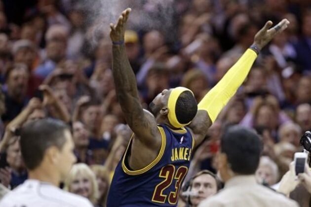 Cleveland Cavaliers' LeBron James tosses chalk in the air before the start of an NBA basketball game against the New York Knicks Thursday, Oct. 30, 2014, in Cleveland. (AP Photo/Tony Dejak)