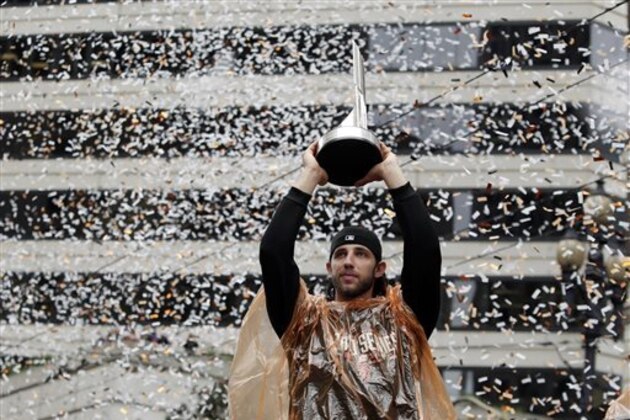 San Francisco Giants pitcher Madison Bumgarner holds the World Series MVP trophy during the victory parade for the 2014 baseball World Series champions, Friday, Oct. 31, 2014, in San Francisco. (AP Photo/Marcio Jose Sanchez)