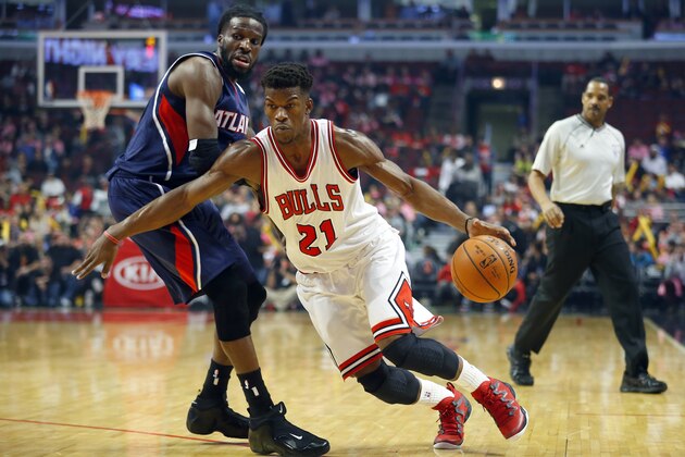 Chicago Bulls guard Jimmy Butler (21) gets past Atlanta Hawks forward DeMarre Carroll during the first half of a preseason NBA basketball game in Chicago, on Thursday, Oct. 16, 2014. (AP Photo/Jeff Haynes)
