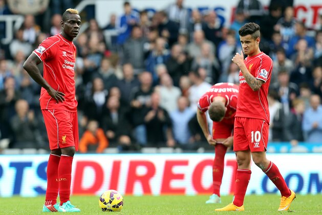 Liverpool's Mario Balotelli, left, and Phillippe Coutinho, right, stand dejected as Newcastle United's Ayoze Perez celebrates his goal during their English Premier League soccer match at St James' Park, Newcastle, England, Saturday, Nov. 1, 2014. (AP Photo/Scott Heppell)