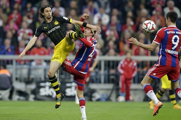 Dortmund's Neven Subotic, left, and Bayern's Thomas Mueller challenge for the ball during the German first division Bundesliga soccer match between FC Bayern and Borussia Dortmund in the Allianz Arena in Munich, Germany, on Saturday, Nov. 1, 2014. (AP Photo/Matthias Schrader)