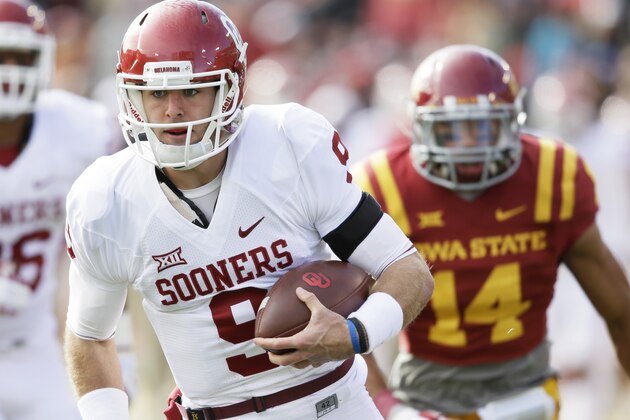 Oklahoma quarterback Trevor Knight runs from Iowa State linebacker Jared Brackens (14) during a 31-yard touchdown run in the first half of an NCAA college football game, Saturday, Nov. 1, 2014, in Ames, Iowa. (AP Photo/Charlie Neibergall)