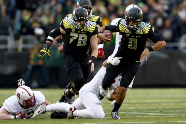 Oregon quarterback Marcus Mariota (8) tries to get away from the defender during the second quarter against Stanford in an NCAA college football game in Eugene, Ore., Saturday, Nov. 1, 2014. (AP Photo/Ryan Kang)