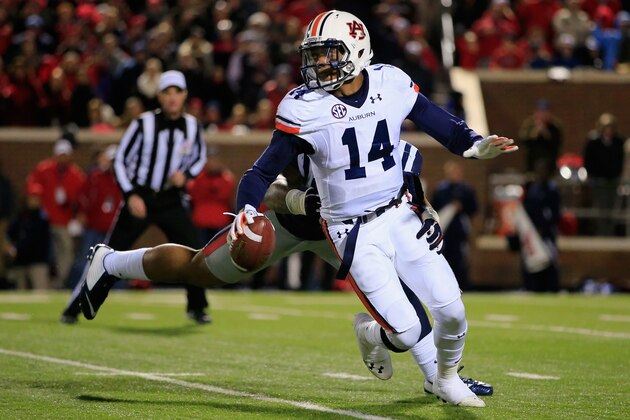 OXFORD, MS - NOVEMBER 01:  Quarterback Nick Marshall #14 of the Auburn Tigers eludes Robert Nkemdiche #5 of the Mississippi Rebels and completes a first down pass in the third quarter at Vaught-Hemingway Stadium on November 1, 2014 in Oxford, Mississippi. Auburn defeated Mississippi 35-31.  (Photo by Doug Pensinger/Getty Images)