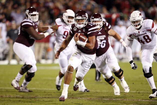 Mississippi State quarterback Dak Prescott (15) runs for a gain against Arkansas defenders in the first half of an NCAA college football game in Starkville, Miss., Saturday, Nov. 1, 2014. (AP Photo/Rogelio V. Solis)