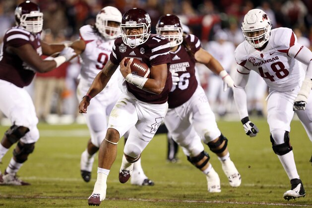 Mississippi State quarterback Dak Prescott (15) runs for a gain against Arkansas defenders in the first half of an NCAA college football game in Starkville, Miss., Saturday, Nov. 1, 2014. (AP Photo/Rogelio V. Solis)