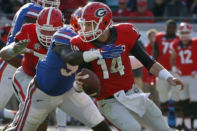 Georgia quarterback Hutson Mason (14) is sacked by Florida defensive lineman Bryan Cox, Jr. (94) during the first half of an NCAA college football game in Jacksonville, Fla., Saturday, Nov. 1, 2014. (AP Photo/Stephen B. Morton)