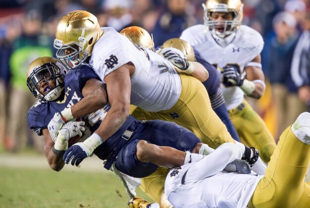 Nov 1, 2014; Landover, MD, USA; Navy Midshipmen fullback Noah Copeland (34) is tackled by Notre Dame Fighting Irish defensive lineman Isaac Rochell (90) and linebacker Jaylon Smith (9) in the fourth quarter at FedEx Field. Notre Dame won 49-39. Mandatory Credit: Matt Cashore-USA TODAY Sports