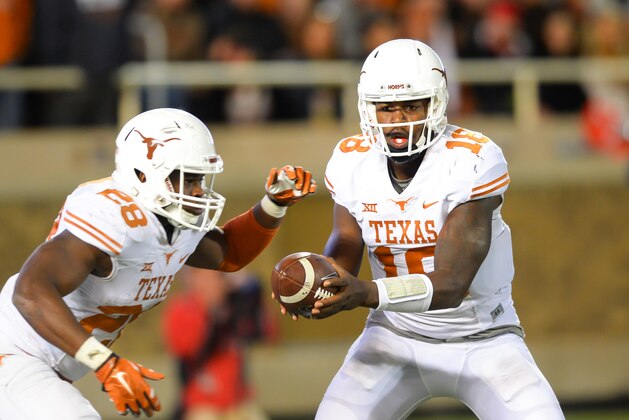 LUBBOCK, TX - NOVEMBER 1: Tyrone Swoopes #18 of the Texas Longhorns hands the ball to Malcolm Brown #28 of the Texas Longhorns during game action against the Texas Tech Red Raiders on November 1, 2014 at Jones AT&T Stadium in Lubbock, Texas. Texas won the game 34-13 .(Photo by John Weast/Getty Images)