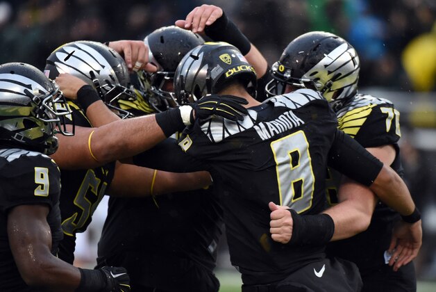 EUGENE, OR - NOVEMBER 1: Quarterback Marcus Mariota #8 of the Oregon Ducks celebrates with his teammates after scoring a touch down during the first quarter of the game against the Stanford Cardinal at Autzen Stadium on November 1, 2014 in Eugene, Oregon. (Photo by Steve Dykes/Getty Images)