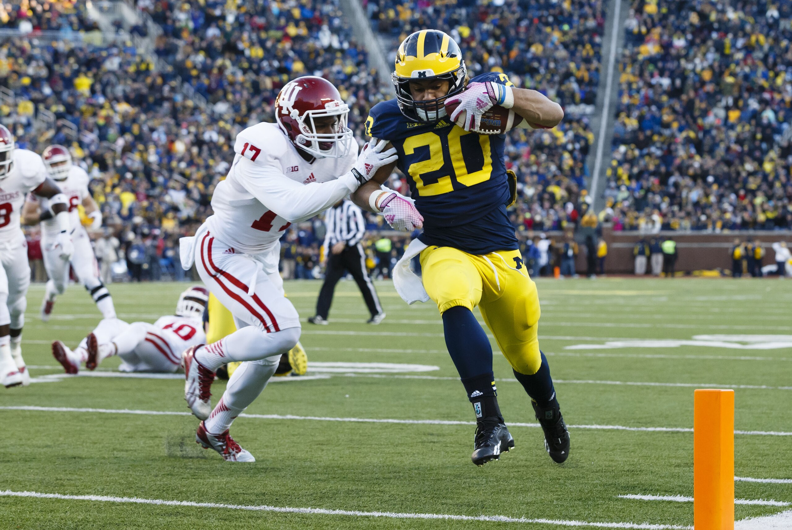 Nov 1, 2014; Ann Arbor, MI, USA; Michigan Wolverines running back Drake Johnson (20) duns the ball in for a touchdown Indiana Hoosiers cornerback Michael Hunter (17) attempts to tackle in the third quarter at Michigan Stadium. Mandatory Credit: Rick Osentoski-USA TODAY Sports
