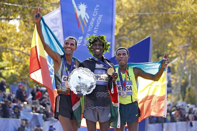 Men's winner Wilson Kipsang, center, is joined by second-place finisher Lelisa Desisa Benti, of the United States, left, and third place finisher Gebre Gebremariam, of Ethiopia, after the 44th annual New York City Marathon in New York, Sunday, Nov. 2, 2014.  (AP Photo/Kathy Willens)