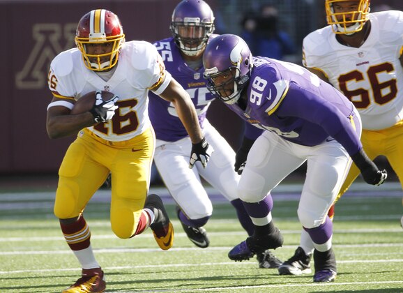 Washington Redskins running back Alfred Morris, left, runs from Minnesota Vikings defensive tackle Linval Joseph (98) during the first half of an NFL football game, Sunday, Nov. 2, 2014, in Minneapolis. (AP Photo/Ann Heisenfelt)