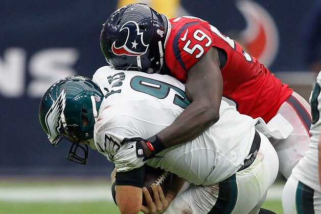 HOUSTON, TX - NOVEMBER 02:  Nick Foles #9 of the Philadelphia Eagles is sacked by Whitney Mercilus #59 of the Houston Texans in the first quarter at Reliant Stadium on November 2, 2014 in Houston, Texas. Foles left the game after the hit.  (Photo by Bob Levey/Getty Images)