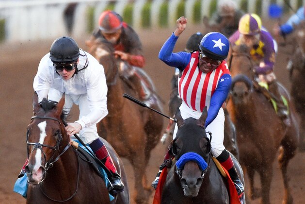 Jockey Martin Garcia celebrates after riding Bayern, right, to victory in the Breeders' Cup Classic horse race past jockey Jamie Spencer on Toast of New York at Santa Anita Park, Saturday, Nov. 1, 2014, in Arcadia, Calif. (AP Photo/Mark J. Terrill)