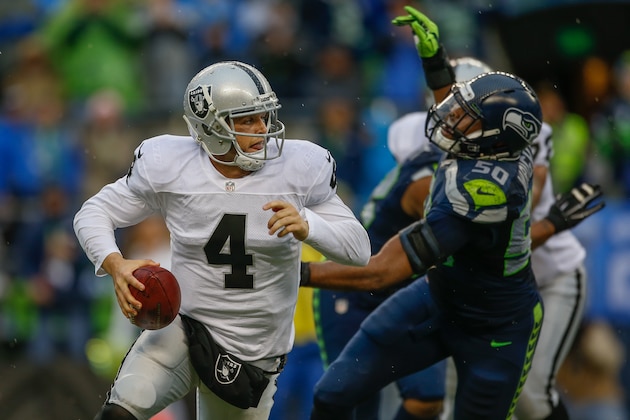 SEATTLE, WA - NOVEMBER 02:  Quarterback Derek Carr #4 of the Oakland Raiders scrambles against outside linebacker K.J. Wright #50 of the Seattle Seahawks at CenturyLink Field on November 2, 2014 in Seattle, Washington. The Seahawks defeated the Raiders 30-24. (Photo by Otto Greule Jr/Getty Images)