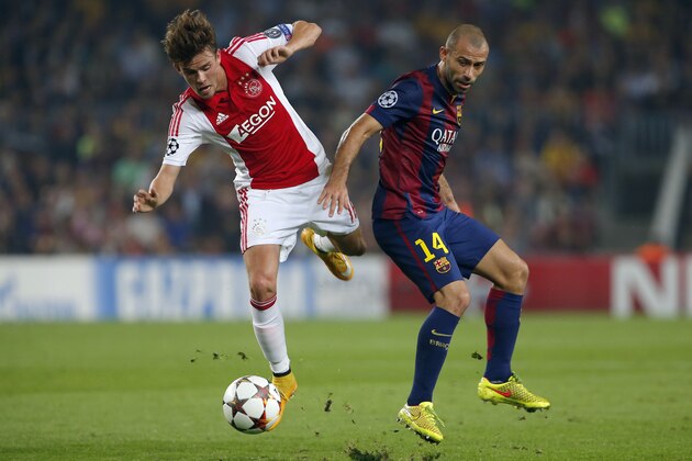 Ajax's Lucas Andersen, left, challenges for the ball with Barcelona's Javier Mascherano during the Champions League group F soccer match between F.C. Barcelona and Ajax at Camp Nou stadium in Barcelona, Spain, Tuesday, Oct. 21, 2014. (AP Photo/Emilio Morenatti)