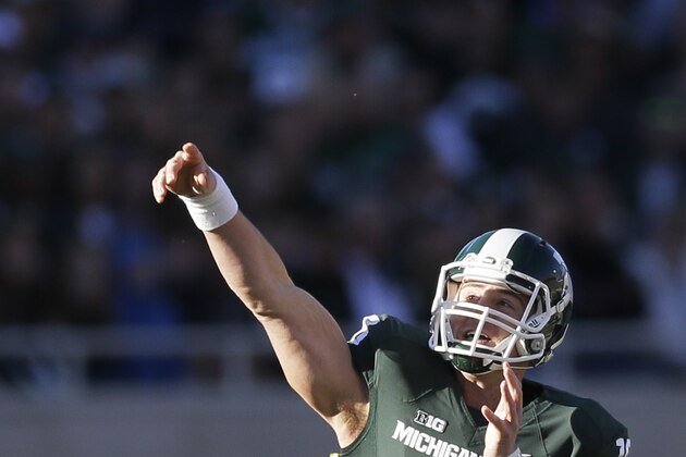 Michigan State  quarterback Connor Cook (18) throws during the first half of an NCAA college football game against Michigan in East Lansing, Mich., Saturday, Oct. 25, 2014. (AP Photo/Carlos Osorio)