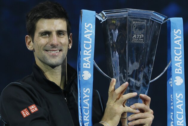 Novak Djokovic of Serbia holds up the ATP World Tour Finals tennis trophy as he poses for photographers after defeating Rafael Nadal of Spain at the O2 Arena in London, Monday, Nov. 11, 2013. (AP Photo/Kirsty Wigglesworth)