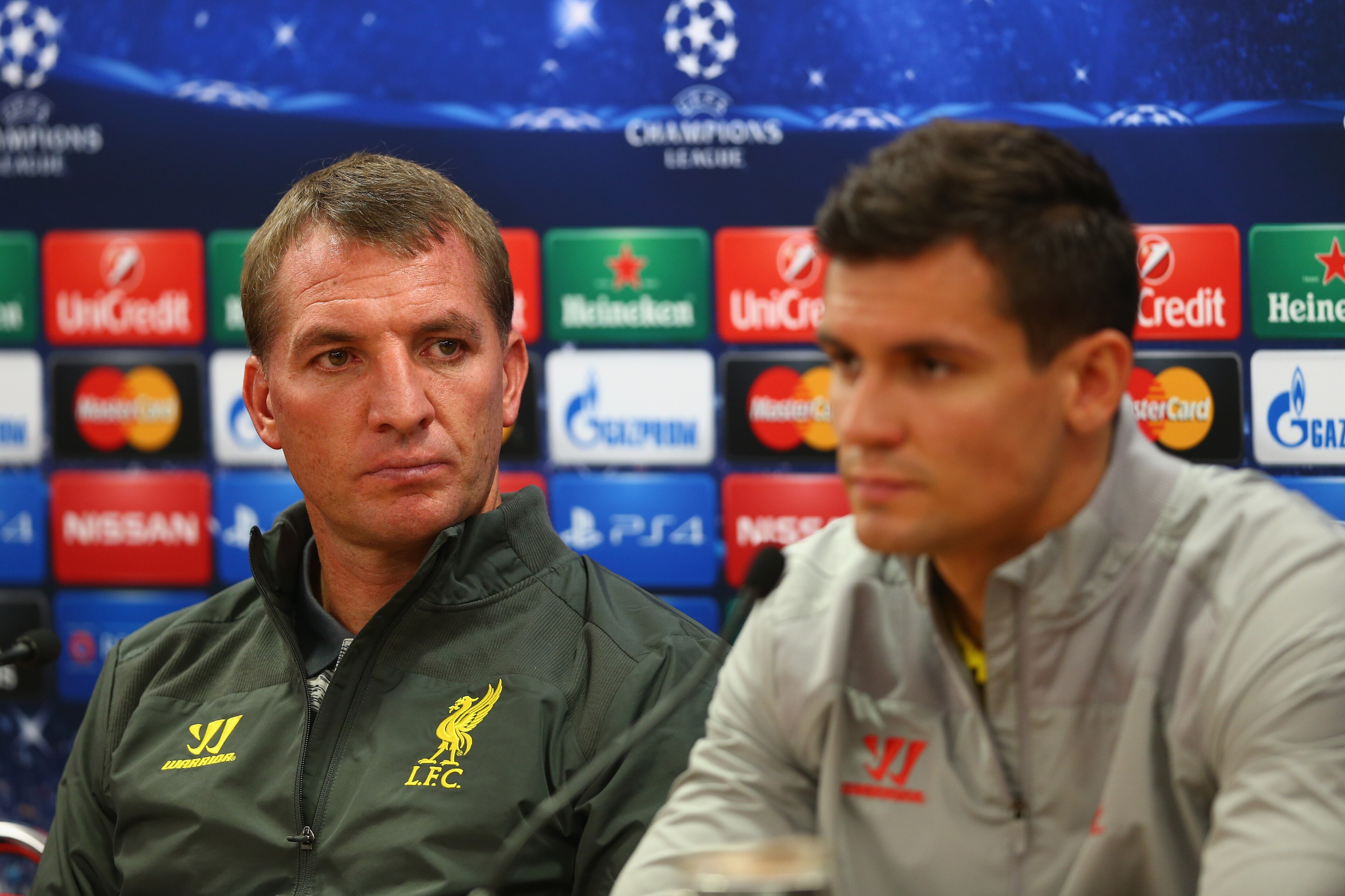 LIVERPOOL, ENGLAND - SEPTEMBER 15:  Liverpool manager Brendan Rodgers deep in thought whilst sitting next to his defender Dejan Lovren during a press conference ahead of their UEFA Champions League group B match against PFC Ludogorets on September 15, 2014 in Liverpool, United Kingdom.  (Photo by Clive Brunskill/Getty Images)