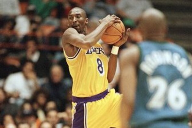 Los Angeles Lakers Kobe Bryant looks for a teammate to pass to as Minnesota Timberwolves James Robinson looks on during their game at the Forum in Inglewood, California on Sunday, Nov. 3, 1996. (AP Photo/Michael Caulfield)