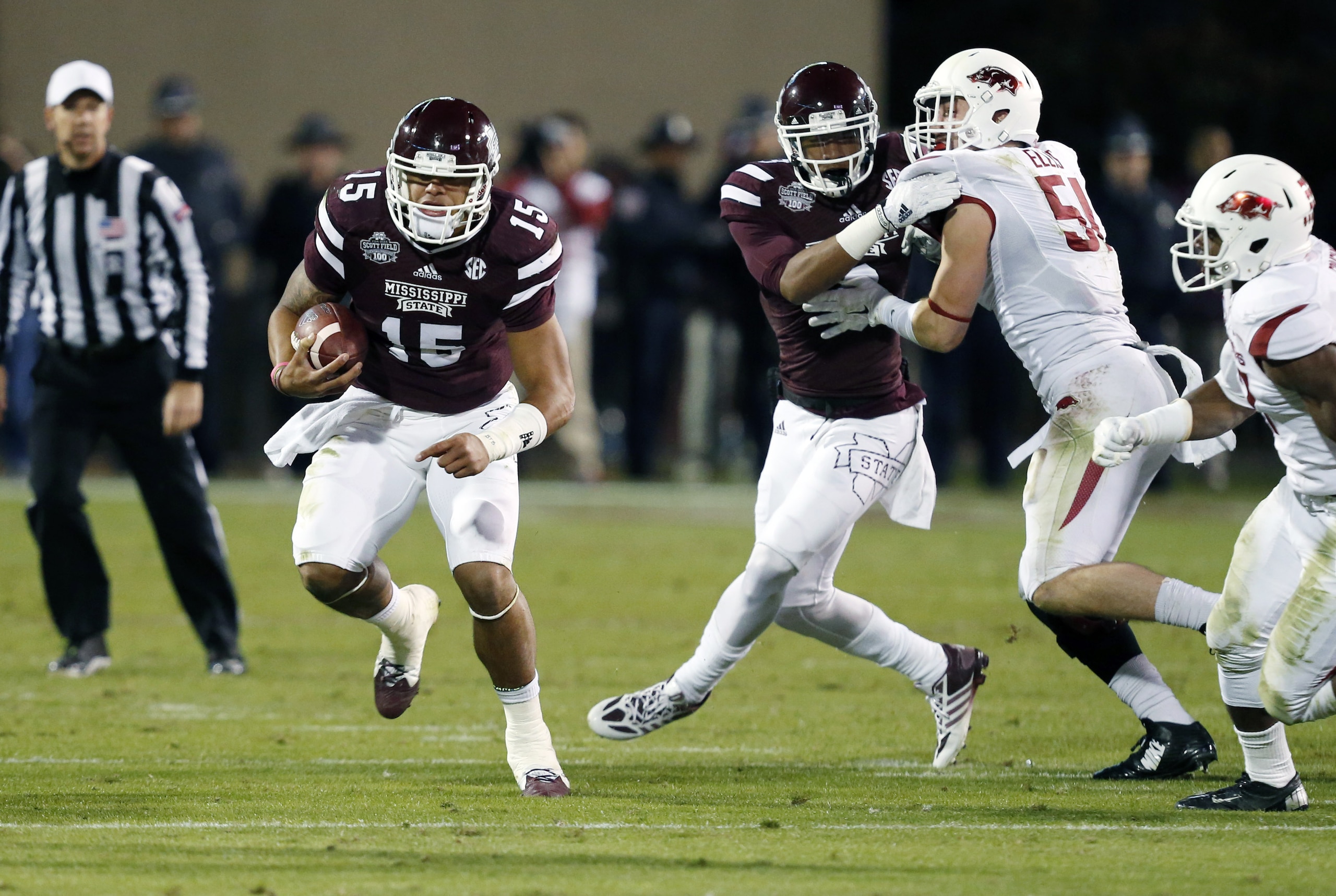 Mississippi State quarterback Dak Prescott (15) runs for a gain against Arkansas defenders in the first half of an NCAA college football game in Starkville, Miss., Saturday, Nov. 1, 2014. No. 1 Mississippi State won 17-10. (AP Photo/Rogelio V. Solis)