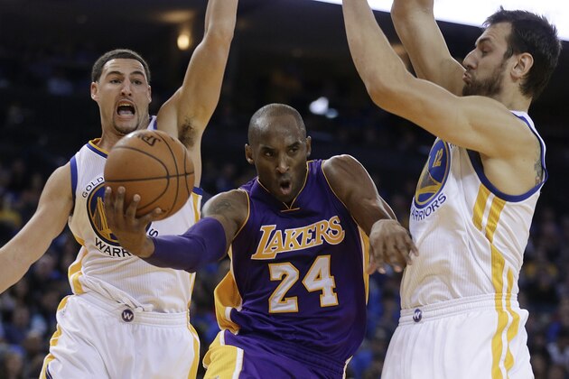Los Angeles Lakers' Kobe Bryant (24) drives the ball between Golden State Warriors' Klay Thompson, left, and Andrew Bogut during the second half of an NBA basketball game Saturday, Nov. 1, 2014, in Oakland, Calif. (AP Photo/Ben Margot)