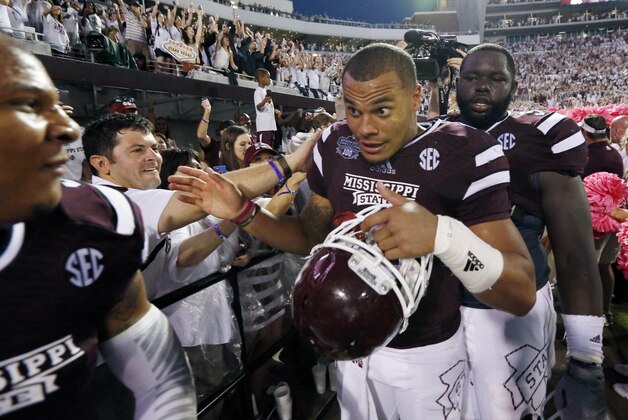 Mississippi State quarterback Dak Prescott, center, celebrates with teammates as they leave Scott Field following their 38-23 win over No. 2 Auburn in an NCAA college football game in Starkville, Miss., Saturday, Oct 11, 2014.  (AP Photo/Rogelio V. Solis)