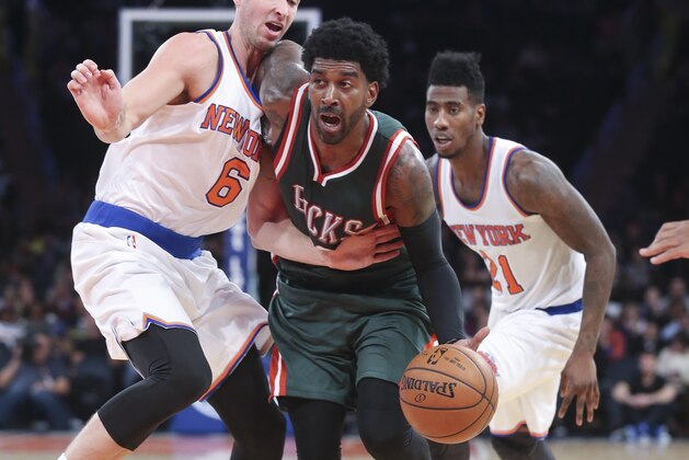 Milwaukee Bucks guard O.J. Mayo, center, dribbles through New York Knicks forward Travis Wear (6) as guard Iman Shumpert (21) looks on in the second half of their preseason NBA basketball game at Madison Square Garden, Monday, Oct. 20, 2014, in New York. The Bucks won, 120-107. (AP Photo/John Minchillo)