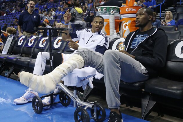 Oklahoma City Thunder guard Russell Westbrook, left, talks with teammate Kevin Durant, right, before the start of a pre-season NBA basketball game against the Utah Jazz in Oklahoma City, Tuesday, Oct. 21, 2014. (AP Photo/Sue Ogrocki)