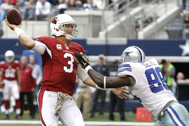 El quarterback Carson Palmer (3) de los Cardinals de Arizona suelta un pase ante el defensive end George Selvie (99) de los Cowboys de Dallas, el domingo 2 de noviembre de 2014. (AP Foto/Brandon Wade)