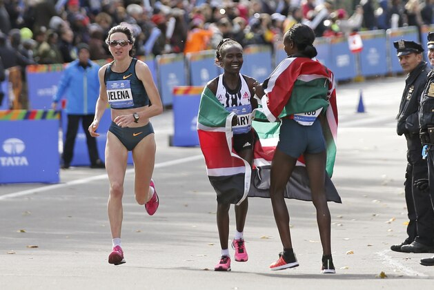 Jelena Prokopcuka of Latvia runs around New York City women's marathon winner Mary Keitany of Kenya, center, as Keitany celebrates with countrywoman and women's runner-up Jemima Sumgong. The pair had a close finish in the the 44th annual New York City Marathon in New York, Sunday, Nov. 2, 2014.  (AP Photo/Kathy Willens)