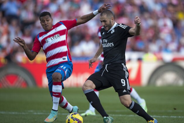 Real Madrid's Karim Benzema from France, right, duels for the ball against Granada's Murillo from Colombia during a Spanish La Liga soccer match between Granada and Real Madrid at the Nuevo Los Carmenes stadium in Granada, Spain Saturday, Nov. 1, 2014. (AP Photo/Daniel Tejedor)