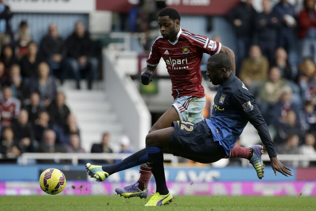 West Ham's Alex Song, left, competes for the ball with Manchester City's Yaya Toure, right front, during the English Premier League soccer match between West Ham and Manchester City at Upton Park stadium in London, Saturday, Oct. 25, 2014. (AP Photo/Matt Dunham)